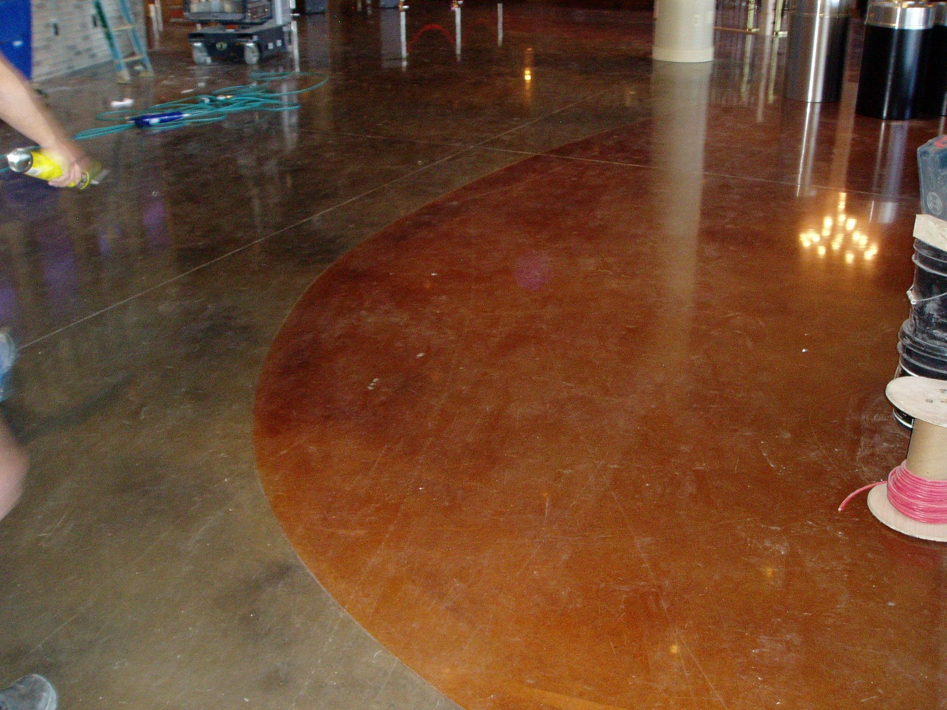 Polished concrete floor in two tones; tan and reddish-brown. Construction setting.