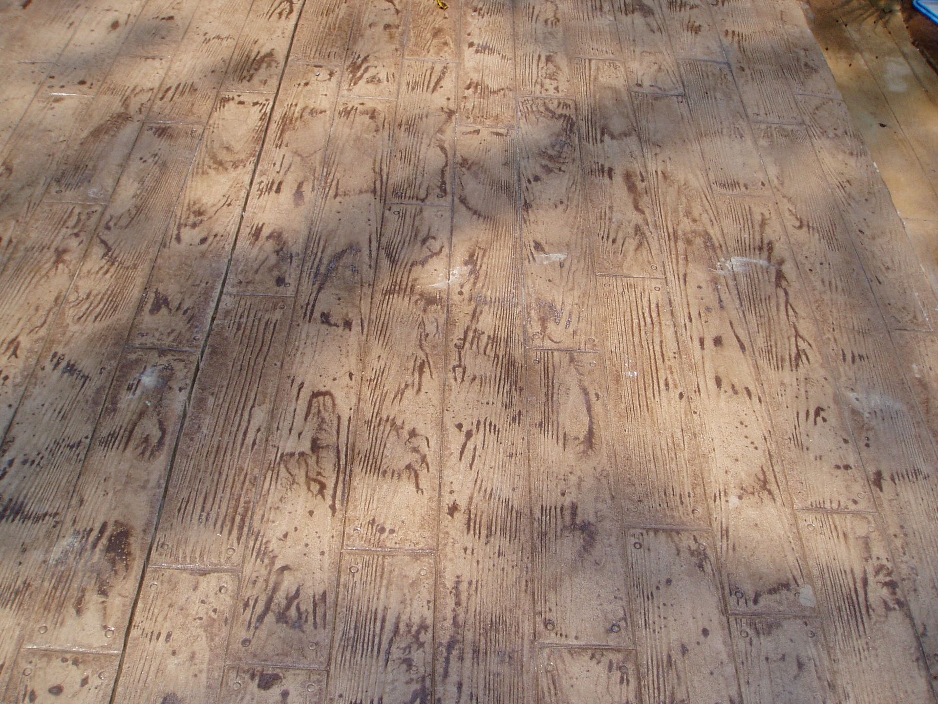 Wood planks with extensive, irregular gouges and indentations.