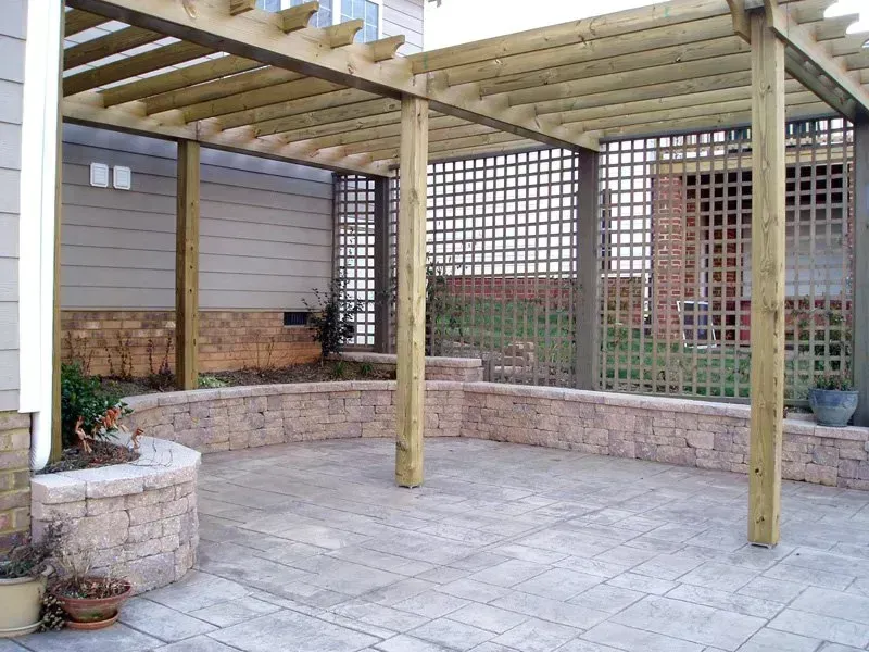 Outdoor patio with pergola, brick wall, and lattice paneling.