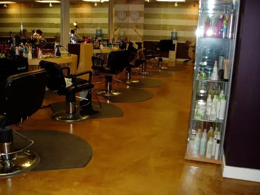 Hair salon interior with styling chairs, mirrors, and product shelves.