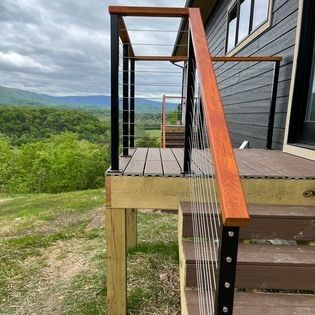 A wooden deck with stairs leading up to it and a view of the mountains.