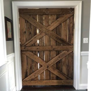 A wooden door with a cross on it is in a room.