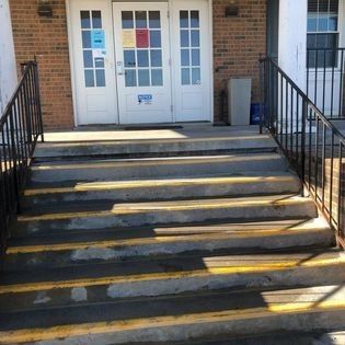 A set of stairs leading up to a building with a railing.