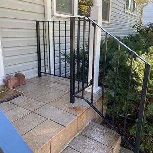There is a wrought iron railing on the porch of a house.