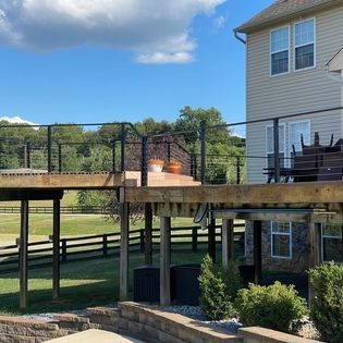 A house with a deck and a fence in front of it