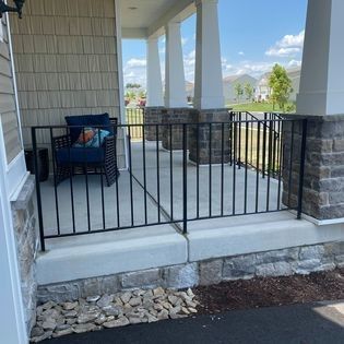 A porch with a fence and a chair on it.
