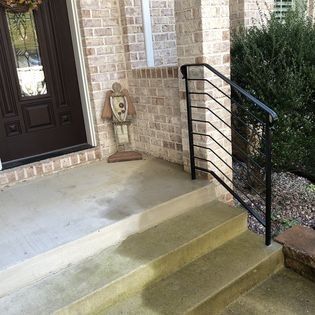There is a statue of a man on the porch of a house.