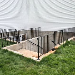 A staircase leading to a basement with a wrought iron railing.