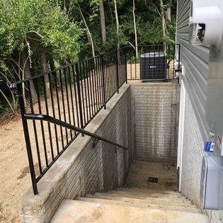 A staircase leading up to a basement with a metal railing.