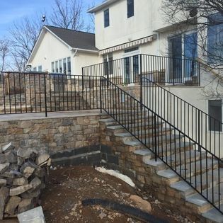 A house with stairs leading up to it and a fence around it.