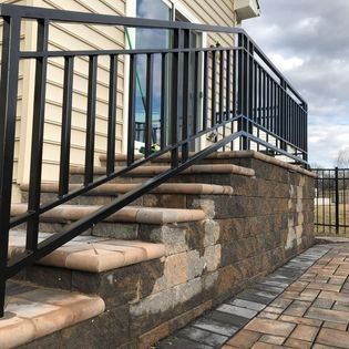 There is a black railing on the steps of a house.