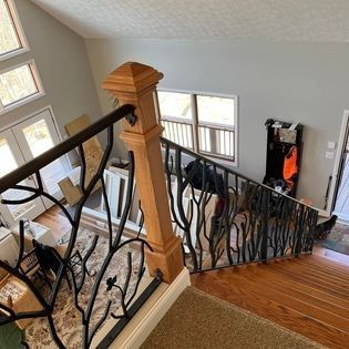 An aerial view of a staircase in a house with a wrought iron railing.