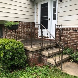 A brick house with stairs leading up to the front door.