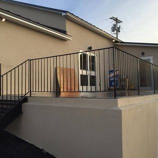 A building with a balcony and stairs on the side of it.
