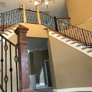 A staircase in a house with a wrought iron railing