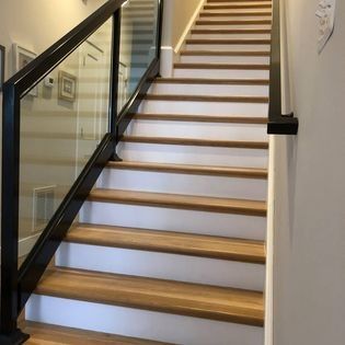 A set of stairs with wooden steps and a glass railing.