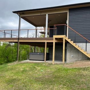 A house with a large deck and stairs leading up to it.