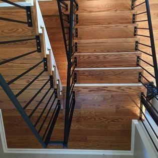 A wooden staircase with a metal railing in a house.
