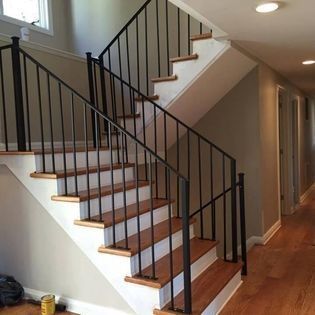 A staircase with wooden steps and a metal railing in a hallway.