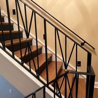 A staircase with a black railing and wooden steps in a house.