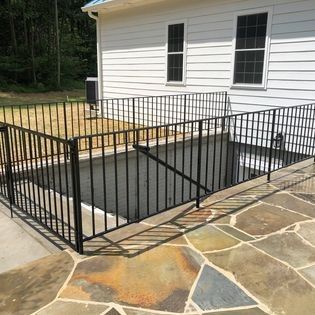 A wrought iron fence surrounds a staircase leading to a basement.