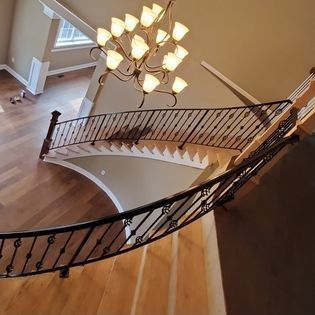 An aerial view of a staircase with a chandelier hanging from the ceiling