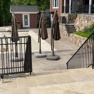 A patio with umbrellas and stairs leading to a house.