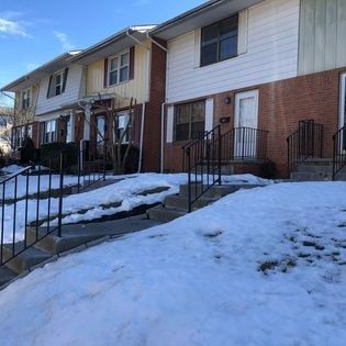 A row of houses with snow on the ground in front of them