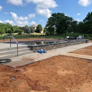 A large swimming pool is being built in a backyard.
