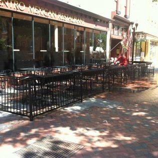 A restaurant with tables and chairs outside of it