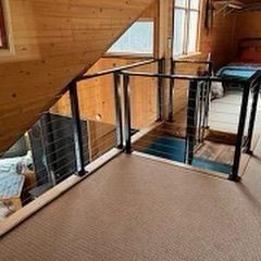 There is a staircase with a glass railing in the middle of the room.