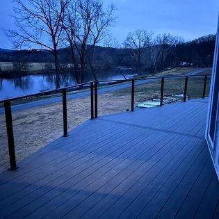 A deck with a view of a river and trees.