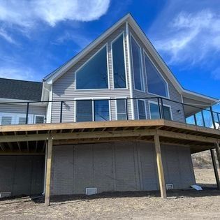 A large house with a large deck and a lot of windows.