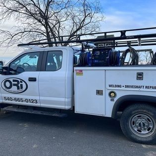 A white truck with the word ori on the side is parked on the side of the road.