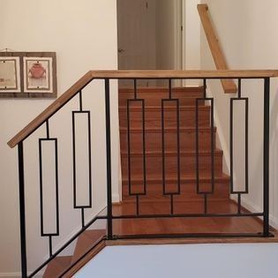 A wooden staircase with a metal railing and a wooden handrail.