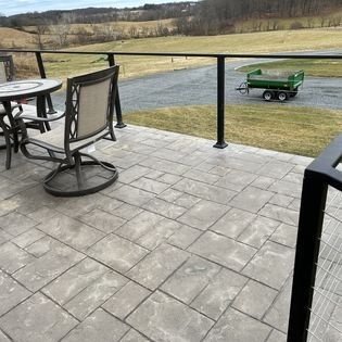 A patio with a table and chairs and a green trailer.