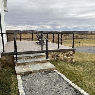 A walkway leading to a deck with stairs and a railing.