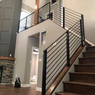 A staircase with a metal railing and wooden steps in a house.