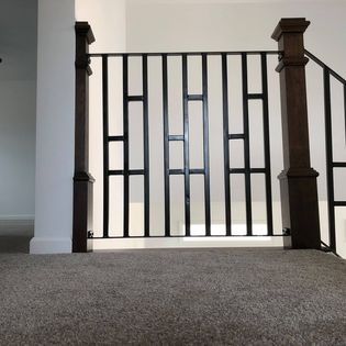 A staircase with a metal railing and wooden posts in a house.