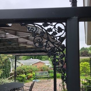 There is a pergola with a table and chairs underneath it.