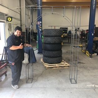 A man standing next to a stack of tires in a garage