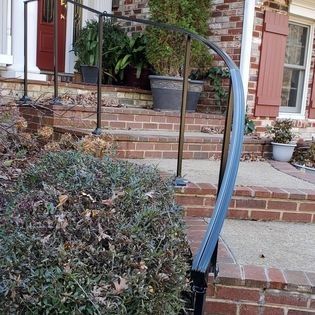 A brick house with a curved railing and stairs
