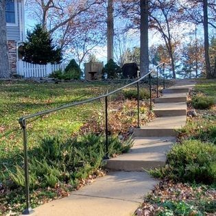A set of stairs leading up to a house with a railing.