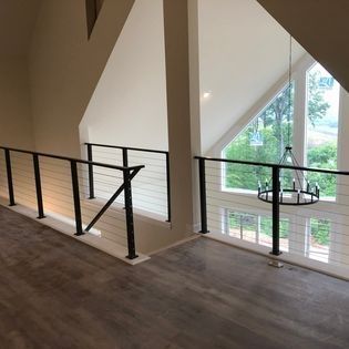 A balcony with a black railing and a chandelier hanging from the ceiling.