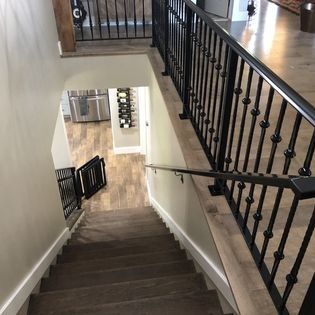A staircase with a black railing leading up to the second floor of a house.