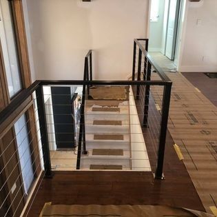 A staircase with a metal railing is being built in a house.