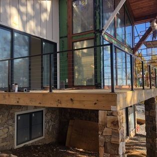 A large house with a wooden deck and a metal railing.
