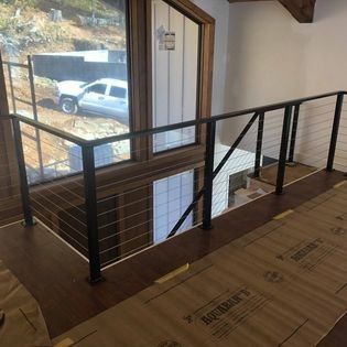 A staircase with a railing and a window with a truck in the background