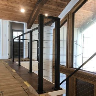 A staircase with a black railing and a wooden floor.