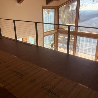 A balcony with a railing and lots of windows in a house.